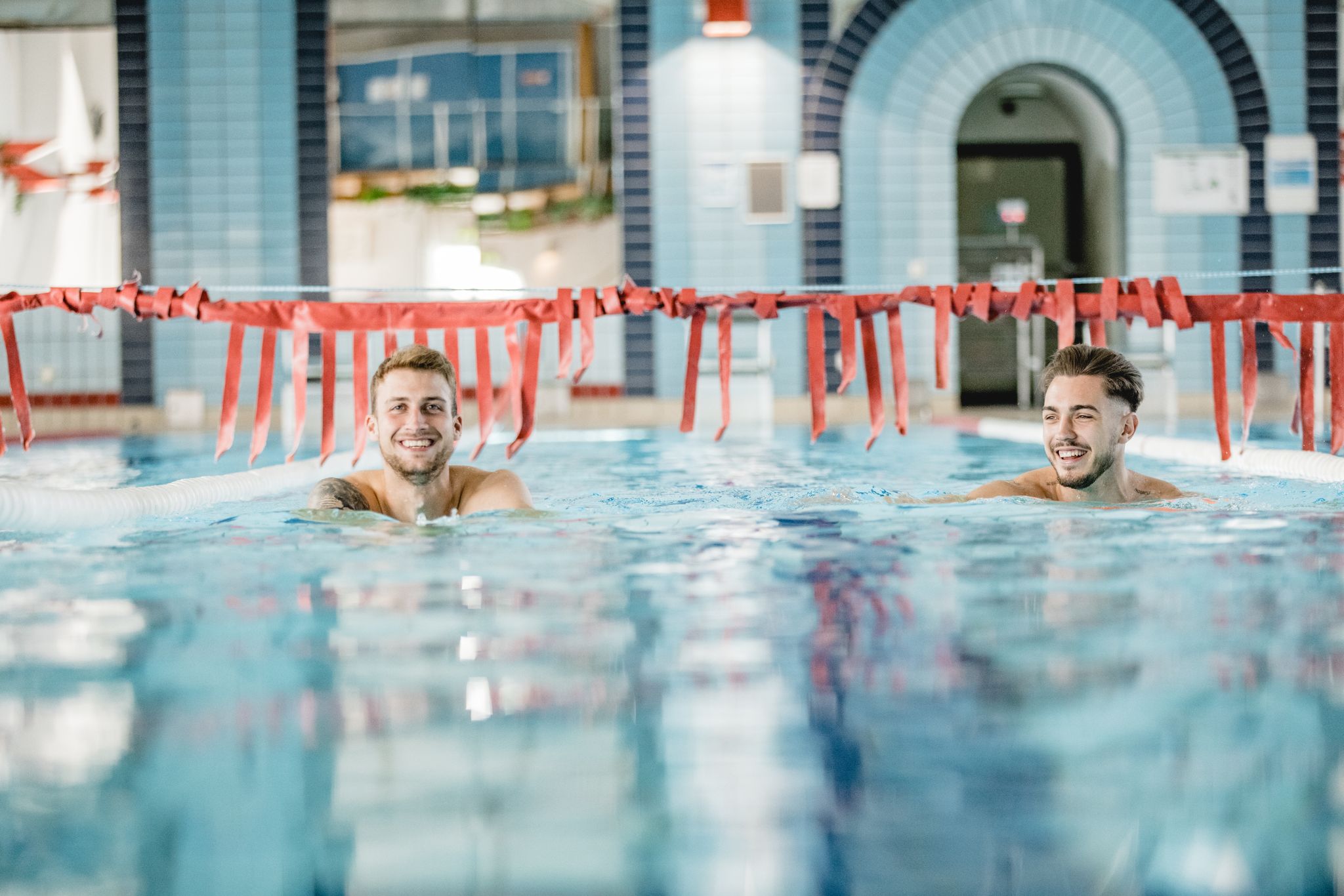 Grafik: Zwei Männer ziehen Bahnen im Schwimmerbecken