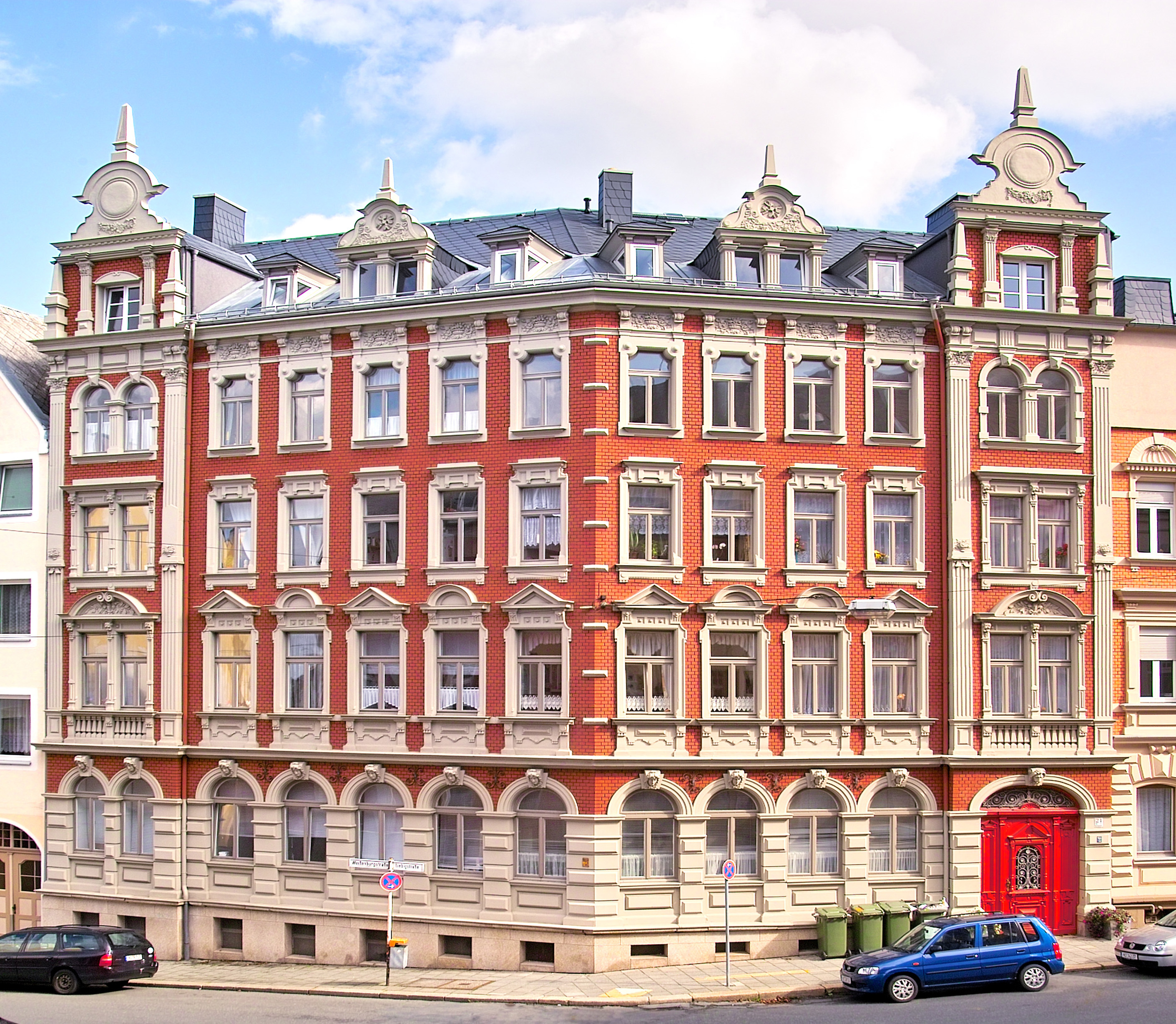 Grafik: Rotes Mehrfamilienhaus im Altbaustil. 